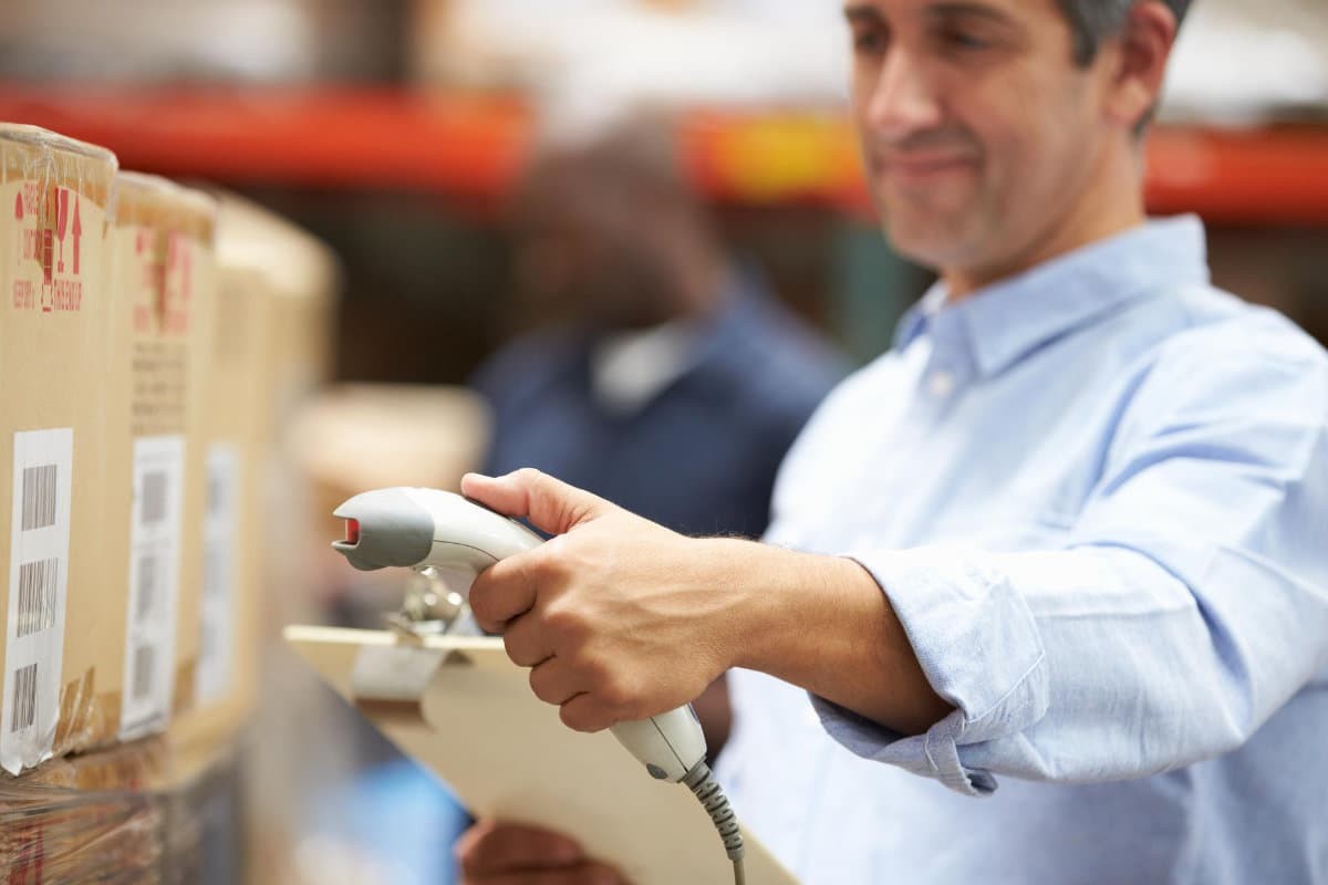 Man scanning barcodes on side of box.